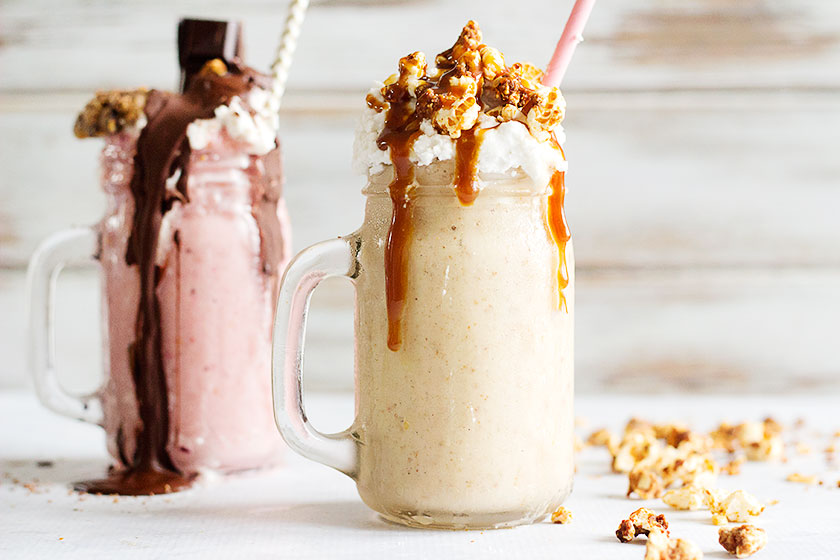 Freakshake - Decadent Vegan Milkshakes | Two delicious flavours - Macadamia, Banana & Vanilla topped with Peanut Butter Caramel and Almond Popcorn, and a Chocolate and Strawberry, topped with vanilla whipped coconut cream and Chocolate Fudge Sauce. The perfect dessert for the summer! #vegan #glutenfree