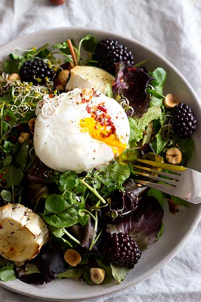 Blackberry & Baked Honey Goat's Cheese Warm Salad Bowl | Baked bubbling honey goat's cheese served with balsamic greens, poached egg, toasted hazelnuts and juicy blackberries | @teffyperk