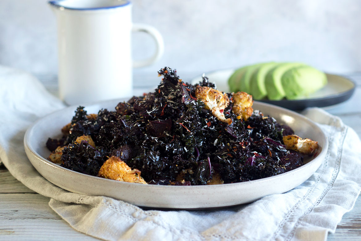 Winter salad with roasted cauliflower and marinated kale - tossed with some coconut! Vegan, paleo, and the perfect Christmas side dish.
